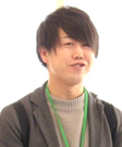 緑色の紐を首から下げている男性の写真