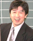 暗い色のネクタイを付けたスーツ姿の男性の写真