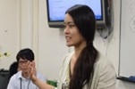ロングヘアの女性が手を動かしながら話している写真