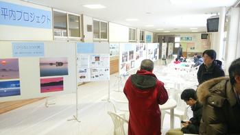 展示されている写真や資料を見ている男性たちの写真