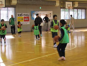 緑のゼッケンと黄緑色のゼッケンをつけた子どもたちがバスケットボールを持っている写真