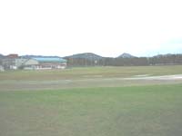 遠景に山や建物が見える陸上競技場の写真