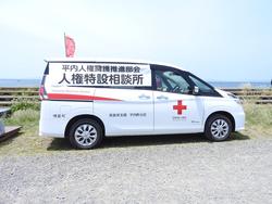 「人権特設相談所」と書かれた幕が付き、赤い十字がペイントされた白い車の写真